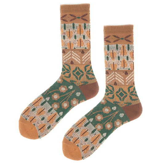 A pair of crew socks with a detailed geometric and floral pattern in brown, green, beige, and orange, displayed against a solid white background.